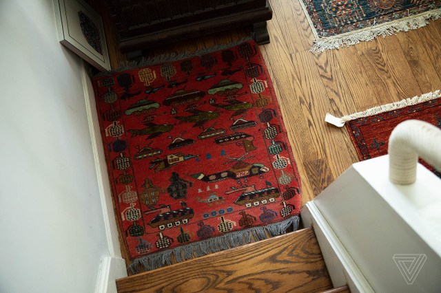 A red rug featuring an outer ring of grenades with tanks, helicopters, jets, and more on the interior.