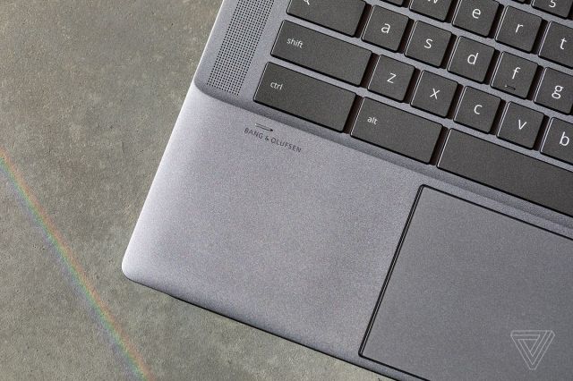 The Bang and Olufsen logo below the left side of the keyboard on the HP Chromebook x360 14c seen from above.