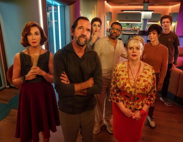 Alice and her guests watching the news, and realizing that they’re all trapped in her house.