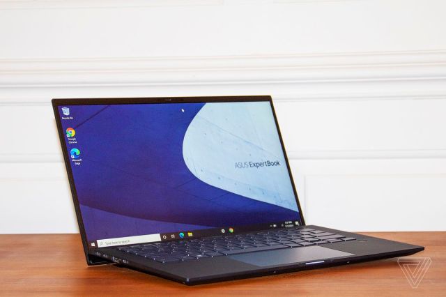The Asus ExpertBook B9450 open, angled slightly to the right. The screen displays the Asus ExpertBook logo on a blue and white background.