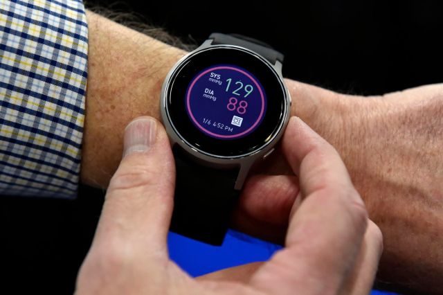 A watch displaying blood pressure reading on a person’s wrist.