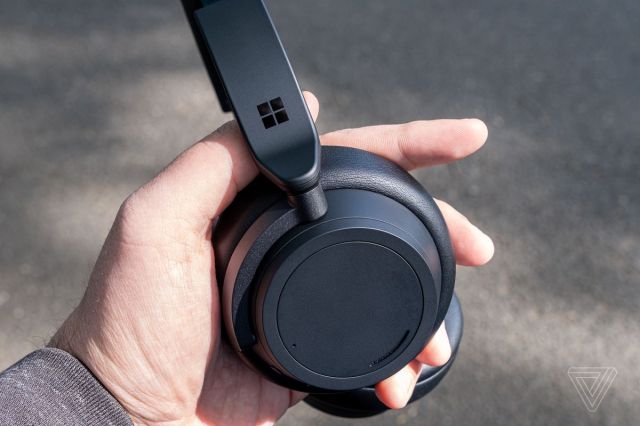 The matte black Surface Headphones 2 pictured in the reviewer’s hand.