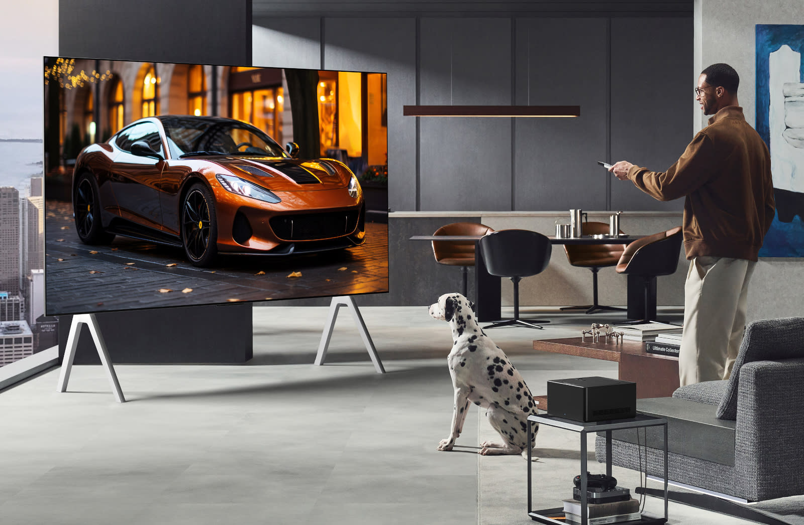A man and his dalmatian gaze at a 77-inch LG OLED TV.