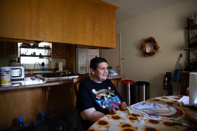 A man sits at a kitchen table.