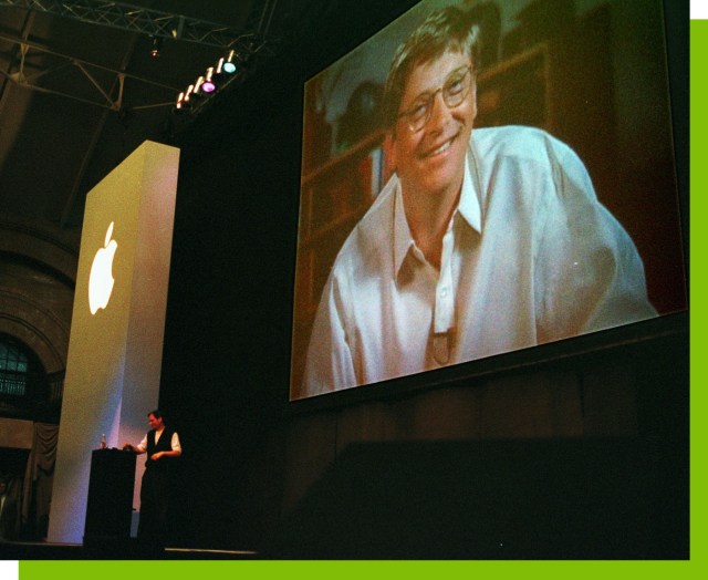 Apple co-founder Steve Jobs, background left, stands at a podium as Bill Gates, chief executive of Microsoft Corp., appears on a video screen during Jobs’ address during the MacWorld convention in Boston.