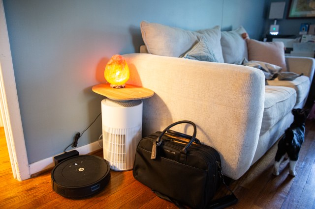 A glowing object on top of a small stand next to a couch.