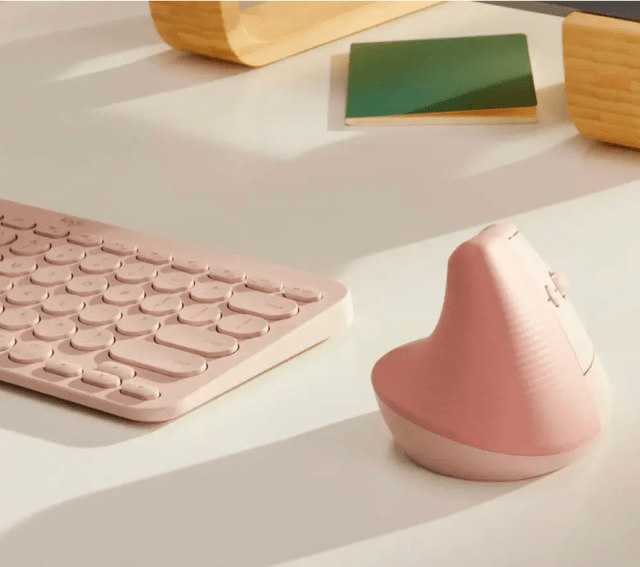 Pink vertical mouse on desk next to pink keyboard