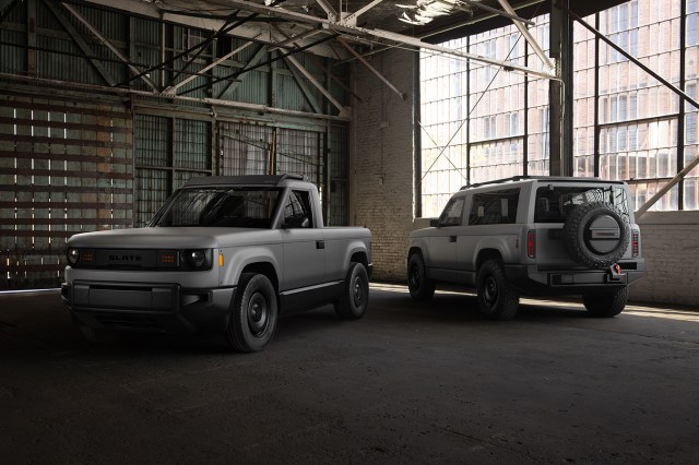 Two cars indoors, with the one on the left facing the camera and the one on the right facing away.