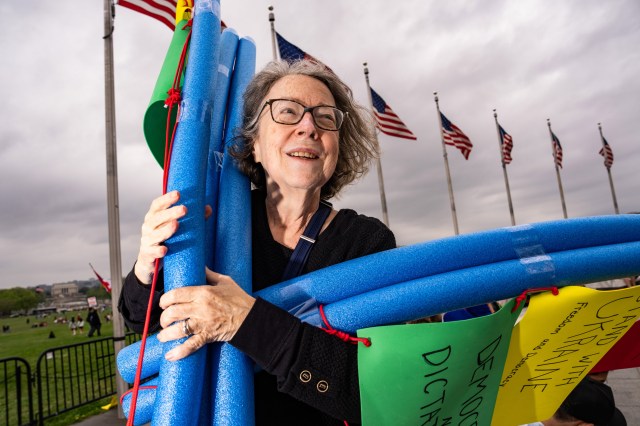 Susan (last name not given) holds a sign she made out of pool noodles during a protest on the National Mall in Washington, DC, US, on Saturday, April 5, 2025. “Hands Off” protests against Trump administration policies are happening in more than 1,000 cities and towns across the country today.