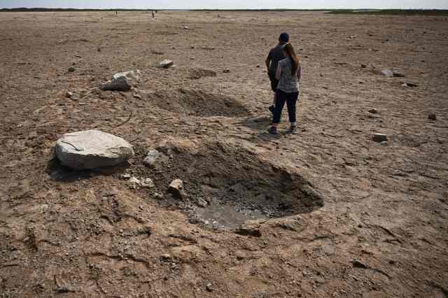 Members of the public walk through a debris field at the launch pad on April 22, 2023, after the SpaceX Starship lifted off on April 20 for a flight test from Starbase in Boca Chica, Texas.