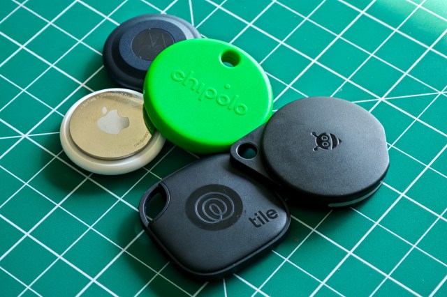 A pile of smart Bluetooth trackers on a green gridded table