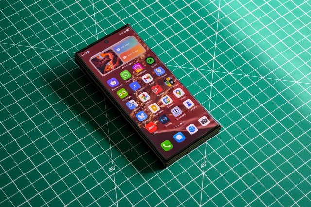 Huawei Mate XT flat on a green table folded.