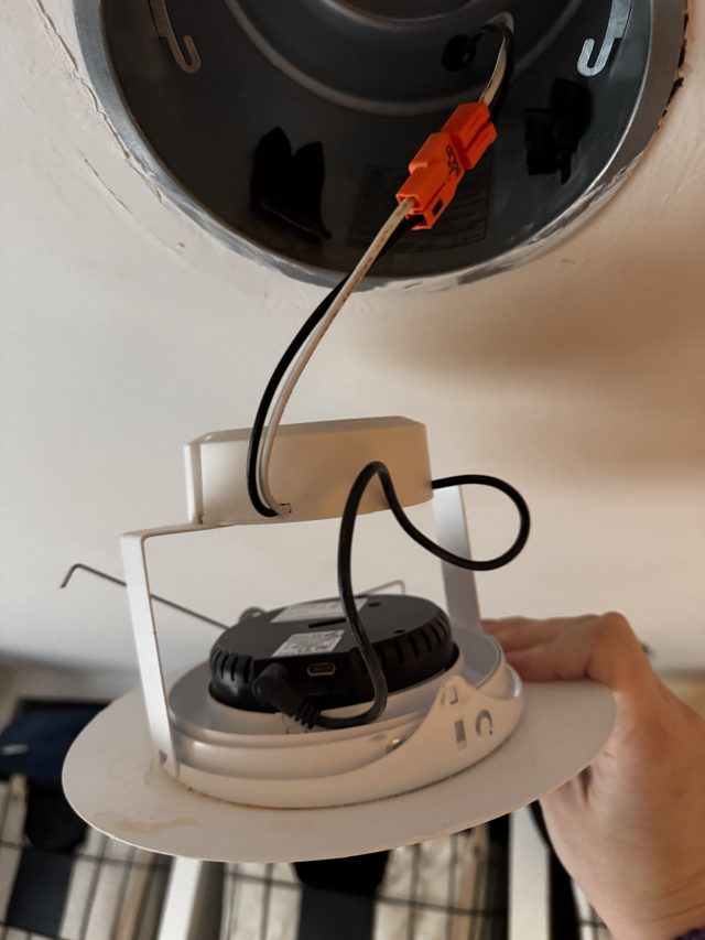 The transmitter fits into the Wi-Charge ceiling light fixture and connects to power via a standard barrel plug.