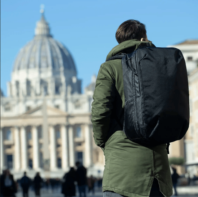Person with backpack facing a capital building.