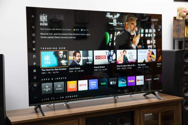 The Vizio Mini LED Quantum display the Vizio OS home page, on a wooden credenza.