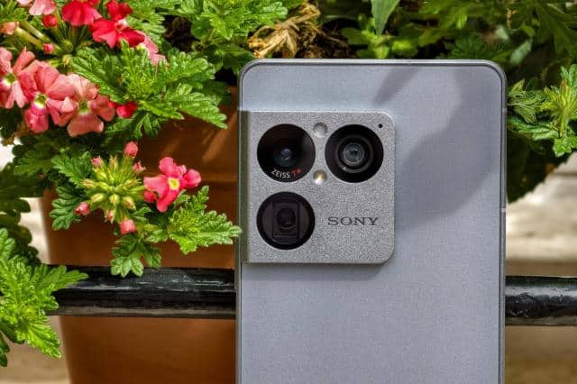 Photo of the Sony Xperia 1 VIII sitting on a windowsill in front of flowers, showing the rear camera