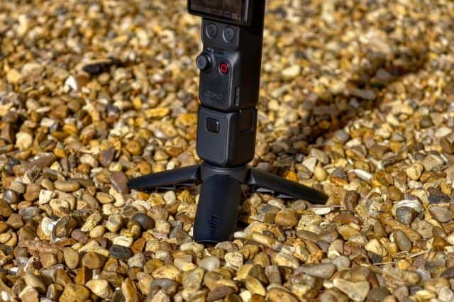 Photo of DJI Osmo Pocket 4P sitting on gravel, showing the tripod attachment.