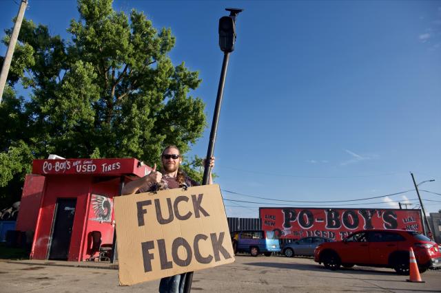 Joshua standing still for a portrait with his prop and sign.