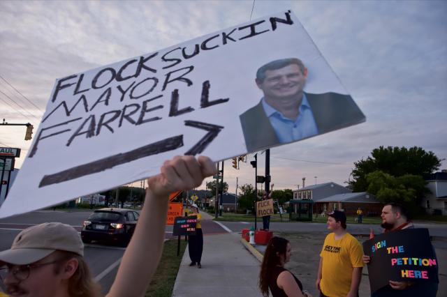 HCAG member holding sign, “Flock Suckin Mayor Farrell” in the foreground.