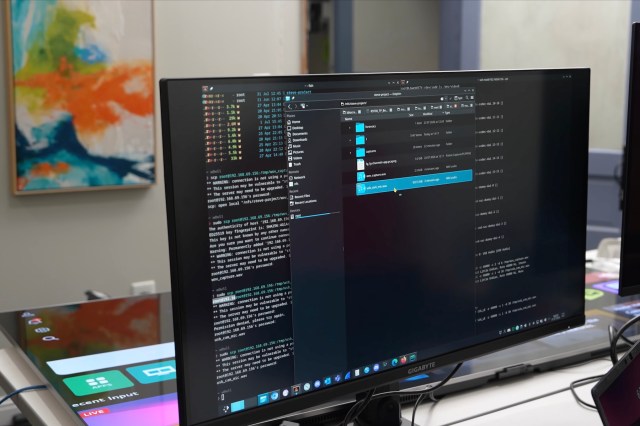 A computer screen showing code with an LG TV lying on the tabel behind it.