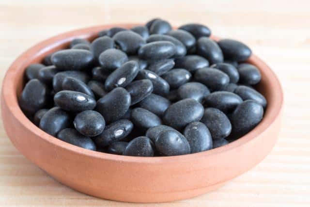 TORONTO, ONTARIO, CANADA – 2017/05/09: Raw turtle black beans or Phaseolus vulgaris in small clay plate. Benefits of black beans include prevention of cardiovascular diseases and cancer. (Photo by Roberto Machado Noa/LightRocket via Getty Images)