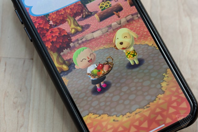 A phone on a table playing Animal Crossing: Pocket Camp.