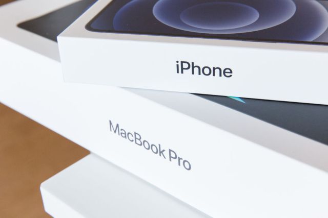 a new iPhone 12 package on top of a MacBook Pro package.