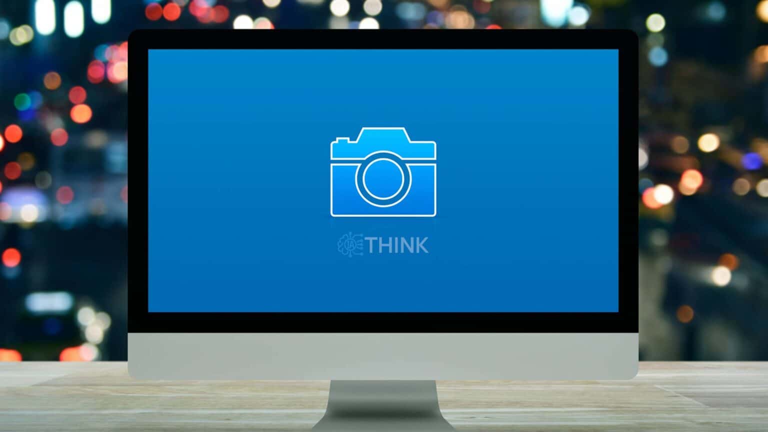 Un monitor mostrando un icono de cámara en un fondo azul, representando un editor de fotos online con IA.