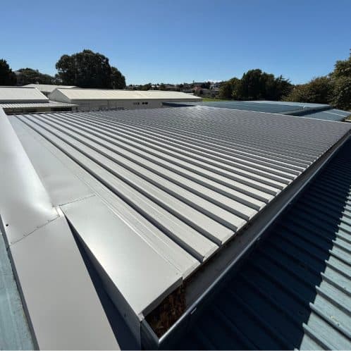 Corrugated metal roofing installed on commercial building in New Zealand, showing durability and weather resistance. Perfect for sustainable roofing solutions with Keola expertise.