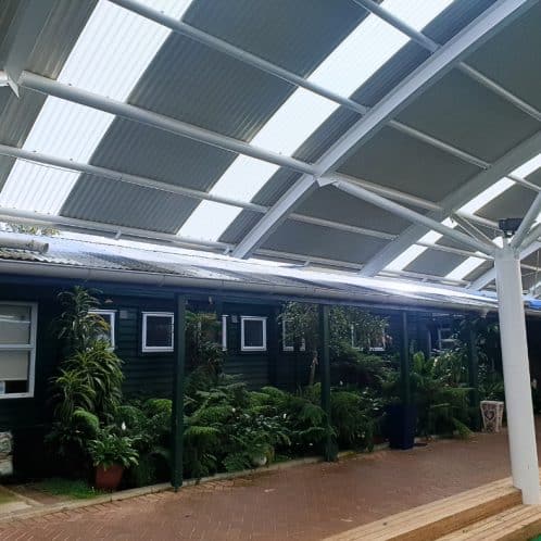 Solar panel covered outdoor patio with lush greenery in New Zealand.