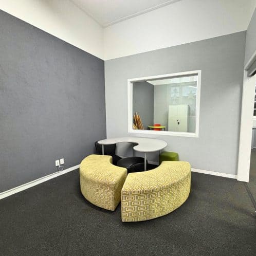 Modern office meeting room with colourful seating and a large window, professional workspace New Zealand, Keola.