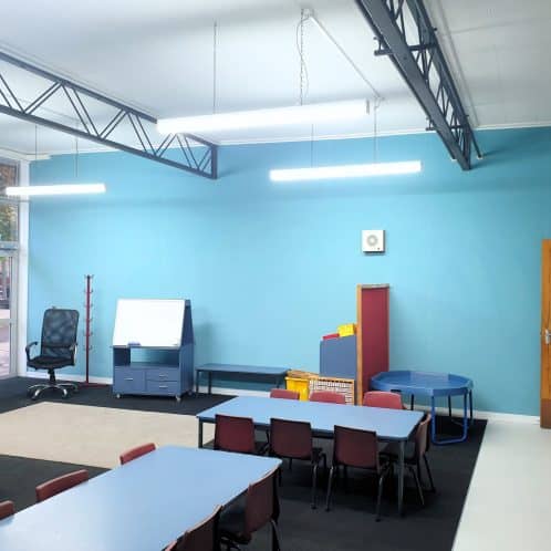 Bright and colourful classroom interior for early childhood education with tables, chairs, and educational decor in New Zealand.