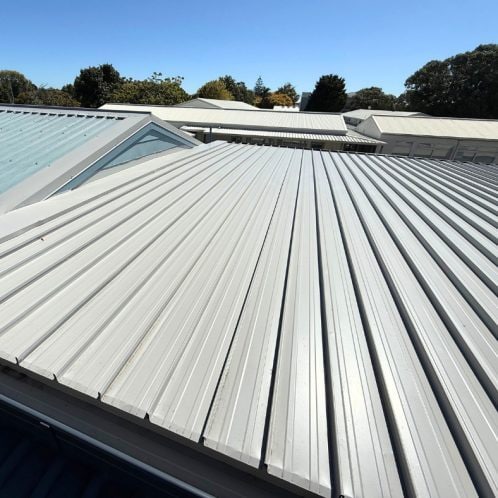 Metal roofing installation on modern commercial buildings in New Zealand.