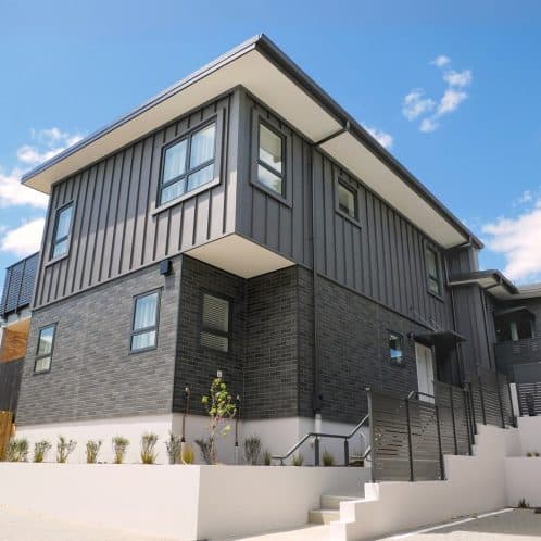 Modern grey brick and metal cladding residential building in NZ, contemporary architecture, stylish home exterior, innovative design, Keola.