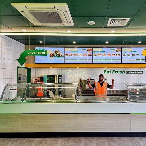 Subway Fresh Forward 2.0 counter area with updated digital menu boards, new service line and Keola site lead during final checks.