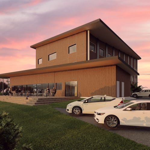 Modern wooden multi-storey building with outdoor terrace during sunset, featuring visitors, parked cars, lush greenery, and a scenic view, highlighting contemporary architecture and lifestyle.