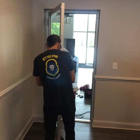 A Locksmith Of One The Best Door Replacement Companies Showcasing Skilled Workers Replacing A Worn-Out Door With Precision And Expertise.