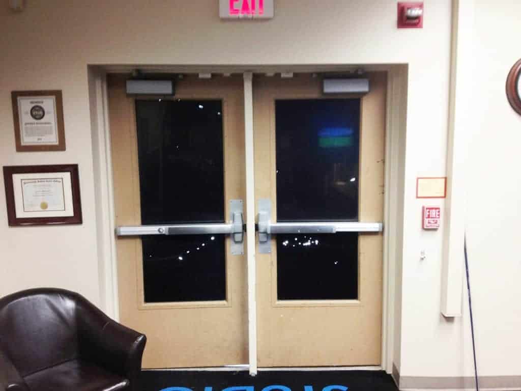 A Photo Of An Exit Door Equipped With A Panic Bar, Showcasing The Effectiveness Of Dc Access Management In Commercial Access Control Systems.