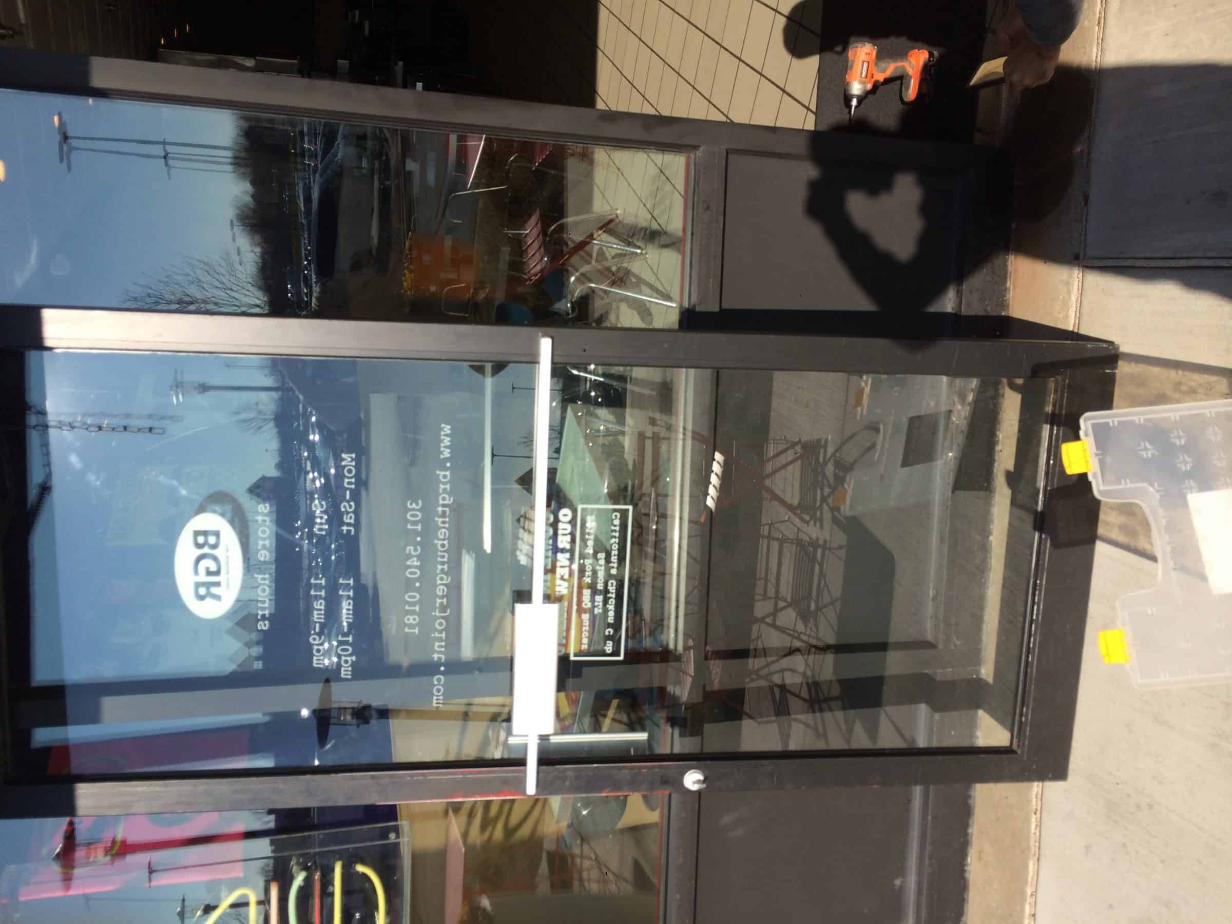 Glass Door With Black Mullions And Silver Door Holder Installed By Commercial Locksmith Washington Dc.&Lt;Br /&Gt;
