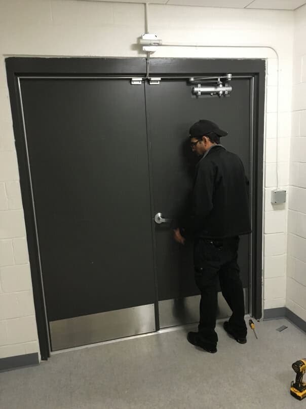 Locksmith Wheaton, Md Wearing Black Inspecting Black Door And Door Knob