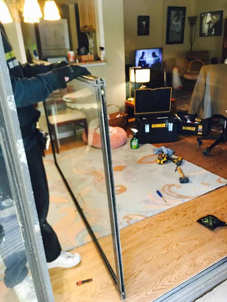 A Locksmith Holding A Glass Door For Emergency Residential Locksmith Services.