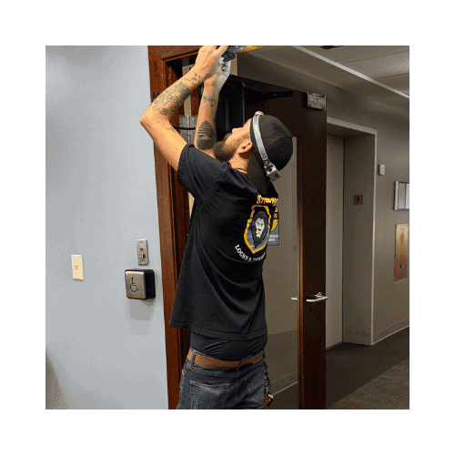 King Locksmith Technician Installing Or Repairing An Ada-Compliant Door System Inside A Commercial Building In Burtonsville, Focusing On Accessibility And Compliance.