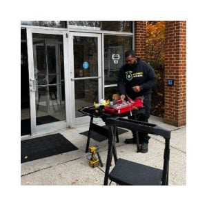 Technician From King Locksmith And Doors Inc. Repairing An Ada-Compliant Door At A Commercial Building Entrance In Hyattsville Md, Showcasing Tools And Equipment For Professional Door Repair Services.
