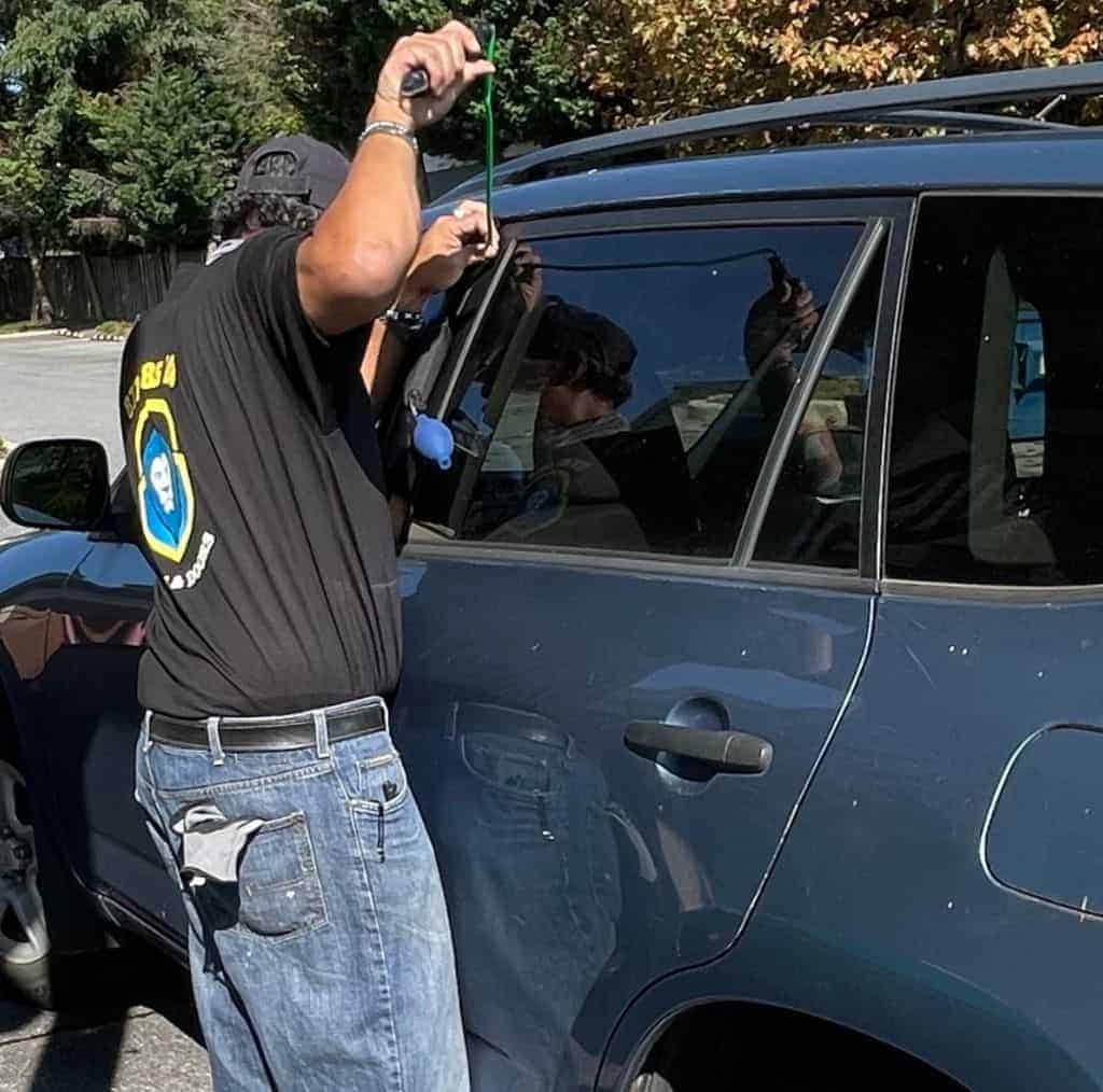 Automotive Locksmith By King Locksmith And Doors Inc King Locksmith'S Personnel Is Busy Opening The Door Of A Car.