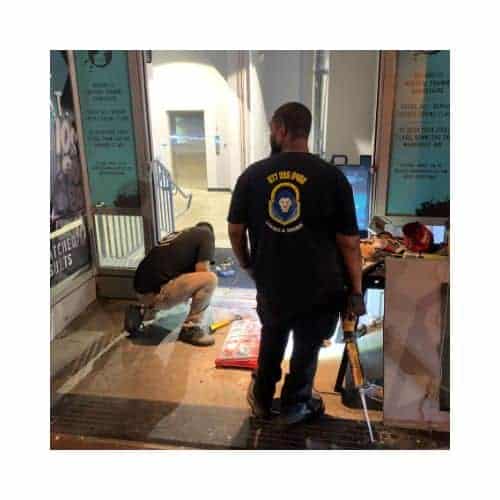 Two King Locksmith Staff Members Wearing Black Uniforms In Md And Dc, Repairing An Aluminum Door Frame In Catonsville