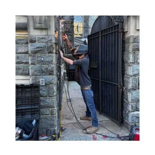 A Locksmith From King Locksmith Welding A Steel Door During A Repair In Catonsville , Md.