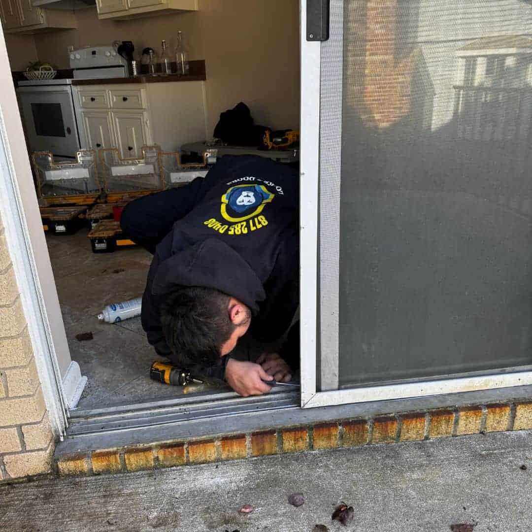 Emergency 18Th Street Ne Locksmith Working On A Sliding Door Lock Repair From The Interior Of A Residential Property.