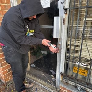 A Georgetown Locksmith Handling An Emergency Lock Repair On A Building'S Door With Precision And Efficiency.