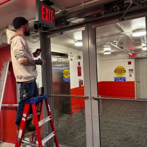 Emergency Locksmith Bladensburg Fixing A Commercial Door Closer System In A Hallway.