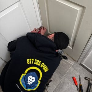 A Professional Residential Locksmith Elkridge Repairing A Door Lock, Ensuring Enhanced Security And Proper Function For The Homeowner